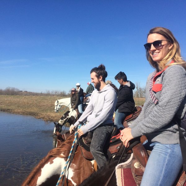 Group of horseback riders enjoying a stop at the pond at our Central Texas dude ranch, which is just twenty minutes away from the heart of San Marcos