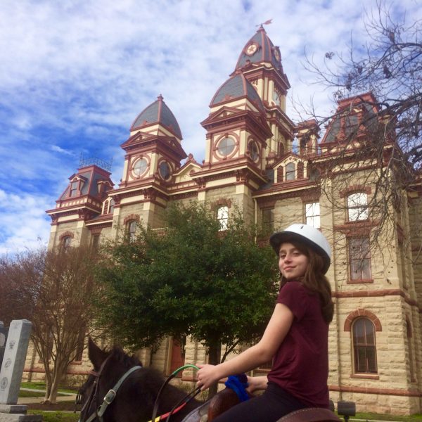 Traveler on horse vacation visits central Texas dude ranch and takes a ride to downtown Lockhart