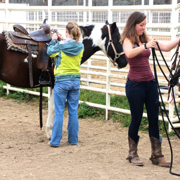 two women getting ready to ride our paint horses